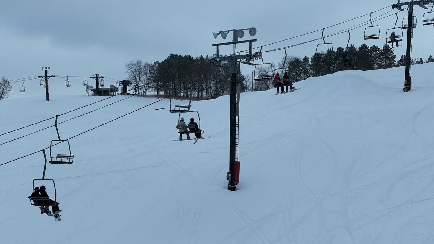 Skiers riding a lift at Steeplechase Ski Area