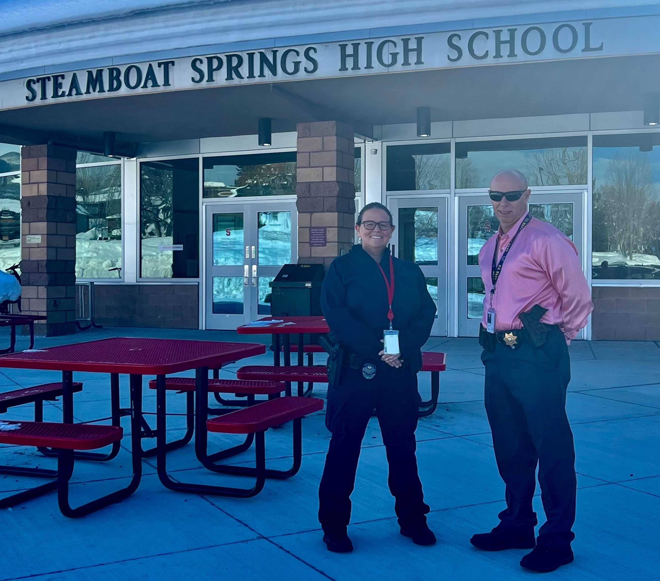 School Resource Officers Lisa Eifling and Stephen Harbison stand in front of the high school